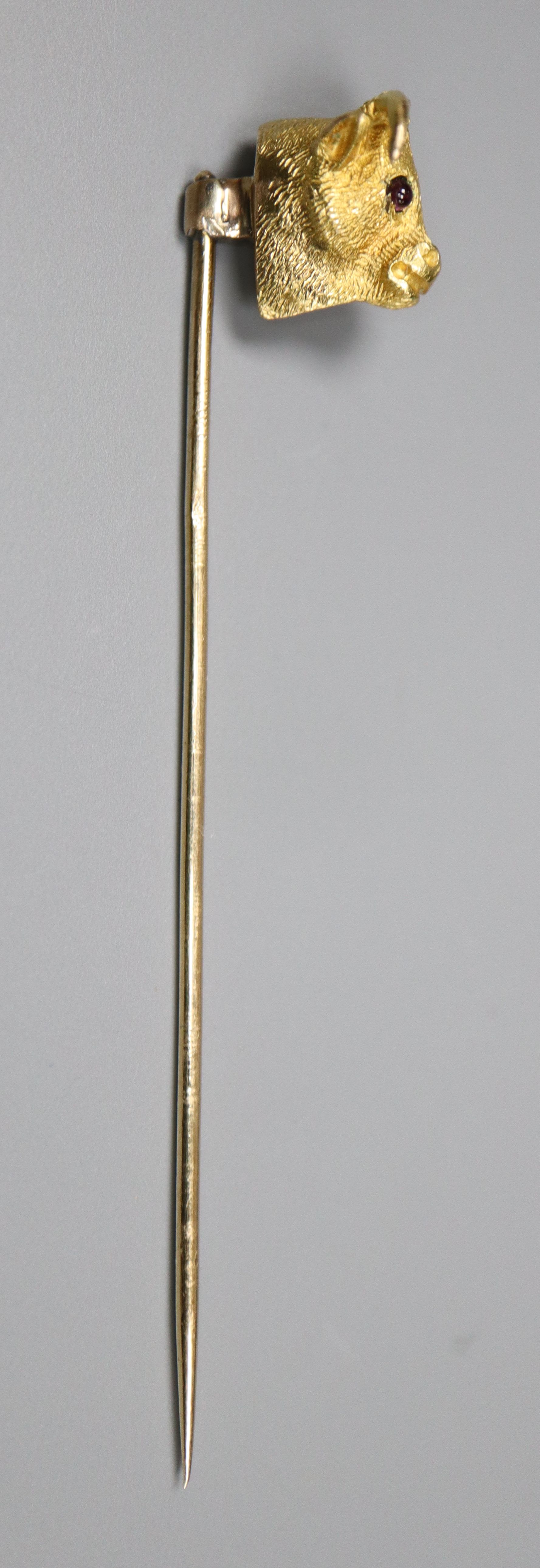 An Edwardian yellow metal and garnet set bulls head stick pin, 65mm, gross 4.4 grams.